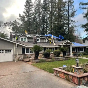 Roof repair crew in Alamo, California working after storm damage to remove debris and secure new materials.